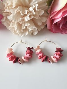 SIZE: Earrings - 4 cm Drop Length - 4 cm MATERIALS: Polymer clay, gold plated hoops These elegant polymer clay hoop earrings feature a delicate arrangement of handcrafted flowers in varyings shades of pink, from soft blush to deep burgundy. Set on lightweight gold hoops, the flowers create a charming, whimsical look, with a few subtle butterfly-shaped pieces interspersed among the blooms. The combination of color and shapes give these earrings a soft, romantic feel, perfect for both everyday wear and special occassions. The earrings are made of polymer clay and it is lightweight. Though polymer clay is a sturdy material, I still suggest to handle your earrings with care to avoid breakage or damage. There will be flaws in the clay, dainty imperfections, due to the baking process. But be ass Gold Hoops Earrings, Earrings Gold Hoops, Earrings Flower, Hoops Earrings, Earrings Polymer Clay, Earrings Hoop, Deep Burgundy, Earrings Unique, Clay Charms