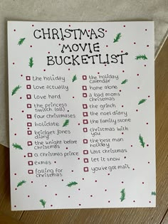 a christmas movie bucket list is shown on a piece of white paper with red and green writing