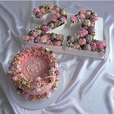 a pink cake with flowers on it and the number 50 next to it