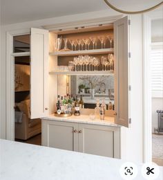 an open cabinet with wine glasses on it