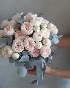 a person holding a bouquet of pink and white flowers