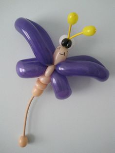 a balloon sculpture of a purple flower with a smiling face