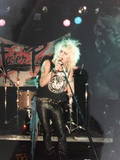 a woman with blonde hair on stage singing into a microphone