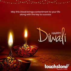 happy diwali greeting card with two lit candles on the table and red background