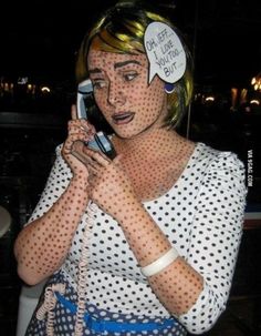 a woman with polka dots on her face talking on a cell phone while holding a purse