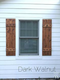 a white house with wooden shutters and a window that has the words dark walnut on it