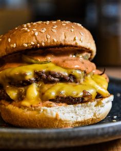 a cheeseburger is sitting on a black plate