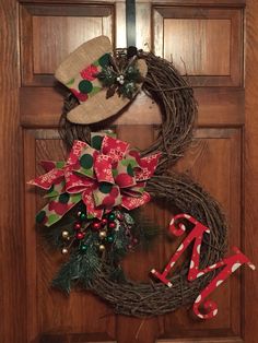 a wreath with the letter m on it and a hat hanging from the front door