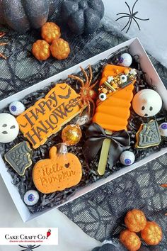 a box filled with halloween treats on top of a table next to pumpkins and other decorations