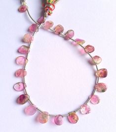 a necklace with pink beads on a white background