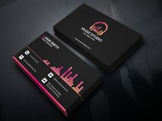 two black and pink business cards sitting on top of a table next to each other