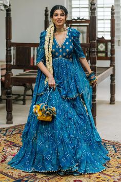 Teal blue attached can-can lehenga with all over bandhani print, accentuated with hand embroidered motifs. Paired with a padded peplum kurta with bandhani print, highlighted with hand embroidered lotus motifs. Comes along with a choker dupatta.
Components: 3
Pattern: Print, Hand Embroidery
Type Of Work: Bandhani, Lotus
Neckline: V Neck
Sleeve Type: Three Quarter Sleeves
Fabric: Banarsi Georgette
Color: Blue
Other Details: 
Lehenga:
Attaced can-can
Tiered detailing
Blouse:
Padded
Sequin laced nec Bandhani Dress Pattern, Reka Bentuk Blaus, V Neck Lehenga, Bandhani Lehenga, Kurta Lehenga, Bandhani Print, Bandhani Dress, Lehenga Designs Simple, Lehnga Dress