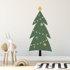 a wall decal with a christmas tree in the middle and stars on it, next to a toy rabbit