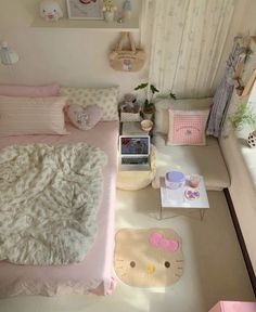 a small bedroom with hello kitty decor on the walls and bed in the corner, along with other items