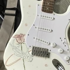 an electric guitar with a rose painted on it