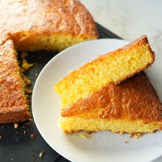 two pieces of cornbread on a plate next to another piece of cake with one slice missing