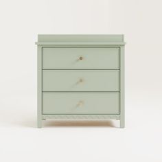 a small green chest of drawers on a white background with the drawer closed and two knobs at the top