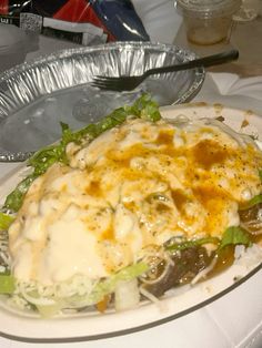 a close up of a plate of food on a table with silver plates and utensils