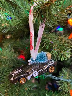 a car ornament hanging from a christmas tree