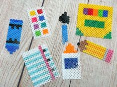 several lego pieces are arranged on a wooden surface, including one with an eraser and the other with colored beads