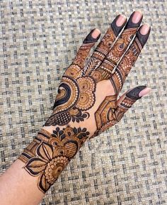 a woman's hand with henna tattoos on it