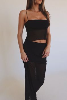 DETAILS: Our Sawyer Midi Skirt Set features contrast mesh panneling throughout to give it a unique and chic look. This set features a cropped tank top with a square neckline, mesh bodice and spaghetti straps as well as a high waisted black midi skirt with a stretchy elastic waistline and mesh hemline. This set is made of a contrasting materials with significant stretch throughout and smooth finish. CONTENT & CARE: TOP: 95% Polyester, 5% Spandex. SIZE & FIT: Model is 5'7" The model is wearing a s Summer Camisole Mesh Top For Night Out, Fitted Sleeveless Mesh Crop Top, Mesh Back Crop Top For Summer, Party Mesh Tank Top With Built-in Bra, Party Mesh Camisole Tank Top, Sheer Mesh Camisole For Summer, Summer Nylon Tube Top For Night Out, Nylon Tube Top For Night Out, Summer Party Nylon Camisole