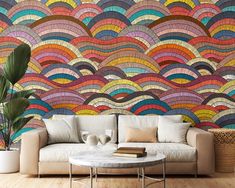 a living room scene with focus on the couch and wallpaper that has an abstract design