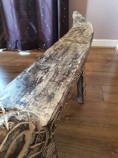 an old wooden bench sitting on top of a hard wood floor next to a curtain