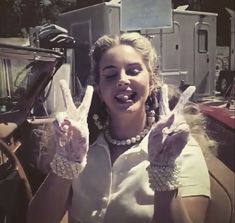 a woman making the peace sign with her hands