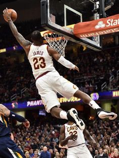 a basketball player jumping up into the air to dunk a ball in front of him