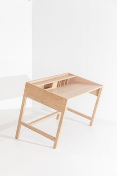 a wooden desk sitting on top of a white floor