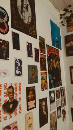 a wall covered in posters and pictures on it