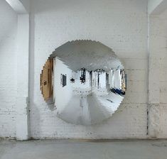 a mirror hanging on the side of a white brick wall