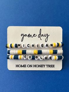 three beaded bracelets with the words game day michigan and home on honey tree