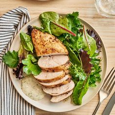 a white plate topped with meat and greens