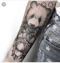 a bear and flowers tattoo on the arm