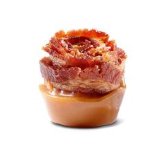 bacon wrapped in sauce sitting on top of a cupcake with caramel toppings