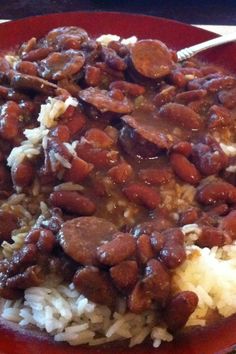 a red plate topped with rice and beans