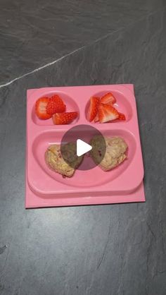 a pink tray with strawberries and cookies on it