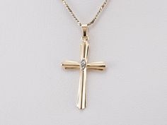 This diamond cross is the perfect everyday piece and would make a great First Communion or Confirmation gift! Crafted of both yellow and white gold, this stately pendant is set with a diamond accent at the center for a look that is special without being ostentatious. This pendant does not come with the chain shown. Please feel free to contact us, we will help you find the perfect chain for your style and budget! Metal: 14K Yellow and White Gold Gem: Diamond Gem Measurements: 0.8 mm, Round Measur Yellow Gold Cross Diamond Necklace For Anniversary, Anniversary Yellow Gold Cross Pendant Diamond Necklace, Anniversary Yellow Gold Diamond Cross Necklace, Yellow Gold Cross Pendant Necklace With Diamond Accents, Yellow Gold Pendant Cross Necklace With Diamond Accents, Cross-shaped Yellow Gold Diamond Necklace, Classic Yellow Gold Diamond Cross Pendant Necklace, Yellow Gold Cross Necklace With Diamond Accents, Yellow Gold Cross Diamond Necklace With Diamond Accents