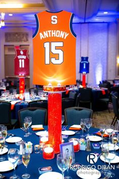 an orange jersey is on top of a blue table cloth at a sports themed event