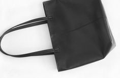 This tote bag features soft black leather and navy interior lining.This bag is small. Carry your phone, a wallet, keys and other small items in this bag. Details:-Dimensions: 11" length (top to bottom), 14.5" top width and 9.5" bottom width (side to side), 5" depth, 9.5" X 5" base (bottom)-Each shoulder strap measures approximately 23" full length-Soft black leather-Cotton interior lining - color can be customized (shown in the picture is burgundy)-One Internal pocketBecause each bag is made by Black Top Handle Shoulder Bag With Card Slots, Black Shoulder Bag With Double Handle And Card Slots, Black Double Handle Shoulder Bag With Card Slots, Black Satchel With Interior Card Slots For Everyday, Everyday Black Satchel With Interior Card Slots, Minimalist Travel Bags With Interior Card Slots, Black Satchel For Daily Use With Interior Card Slots, Casual Black Bag With Interior Card Slots, Casual Black Bags With Interior Card Slots