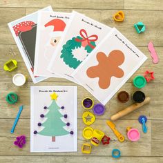 four christmas cards and some crafting supplies on a wooden table with scissors, glue, paper