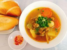 a white bowl filled with soup next to bread