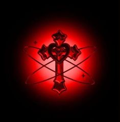 a cross with hearts and stars in the center on a black background, lit up by red light