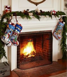 christmas stockings hanging over a fireplace with a fire in the fireplace and presents on it