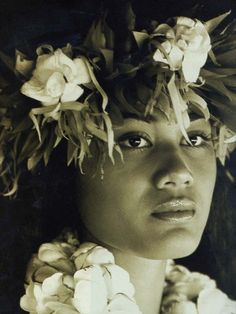 an old photo of a woman with flowers in her hair and wreath on her head