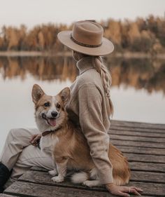 a person sitting on a dock with a dog