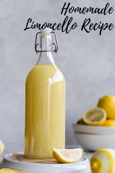 a glass bottle filled with lemonade next to sliced lemons