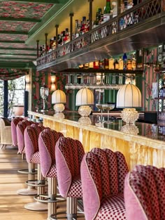 the bar is lined with pink velvet chairs